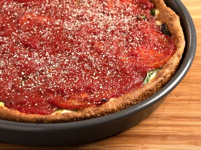 A pan of spinach plus deep dish pizza